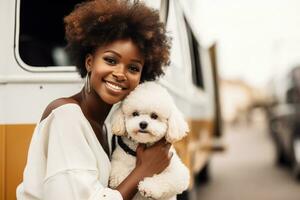 Happy young woman is holding her Bichon Frise dog on her hands standing next to the tourist bus. Traveling with pets concept. AI generated. photo