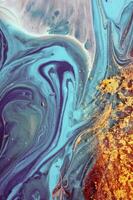 Abstract created using the technique of liquid acrylic. Macro photography of the smallest details of a panting. The panting shows how overflows of shades and colors of paint resemble space motifs. photo