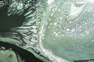 Abstract created using the technique of liquid acrylic. Macro photography of the smallest details of a picture. The picture shows how overflows of shades and colors of paint resemble space motifs. photo