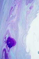 Abstract created using the technique of liquid acrylic. Macro photography of the smallest details of a panting. The panting shows how overflows of shades and colors of paint resemble space motifs. photo