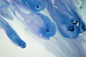 Abstract created using the technique of liquid acrylic. Macro photography of the smallest details of a panting. The panting shows how overflows of shades and colors of paint resemble space motifs. photo