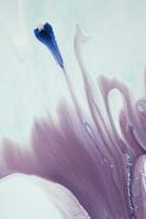 Abstract created using the technique of liquid acrylic. Macro photography of the smallest details of a panting. The panting shows how overflows of shades and colors of paint resemble space motifs. photo