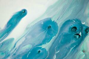 Abstract created using the technique of liquid acrylic. Macro photography of the smallest details of a panting. The panting shows how overflows of shades and colors of paint resemble space motifs. photo