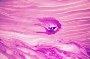 Abstract created using the technique of liquid acrylic. Macro photography of the smallest details of a panting. The panting shows how overflows of shades and colors of paint resemble space motifs. photo