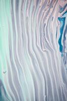 Abstract created using the technique of liquid acrylic. Macro photography of the smallest details of a panting. The panting shows how overflows of shades and colors of paint resemble space motifs. photo