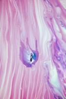 Abstract created using the technique of liquid acrylic. Macro photography of the smallest details of a panting. The panting shows how overflows of shades and colors of paint resemble space motifs. photo