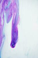 Abstract created using the technique of liquid acrylic. Macro photography of the smallest details of a panting. The panting shows how overflows of shades and colors of paint resemble space motifs. photo