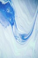 Abstract created using the technique of liquid acrylic. Macro photography of the smallest details of a panting. The panting shows how overflows of shades and colors of paint resemble space motifs. photo