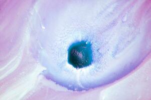 Abstract created using the technique of liquid acrylic. Macro photography of the smallest details of a panting. The panting shows how overflows of shades and colors of paint resemble space motifs. photo