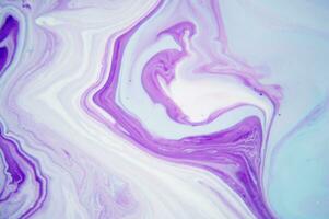 Abstract created using the technique of liquid acrylic. Macro photography of the smallest details of a panting. The panting shows how overflows of shades and colors of paint resemble space motifs. photo