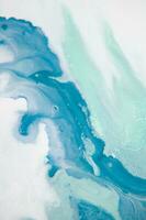 Abstract created using the technique of liquid acrylic. Macro photography of the smallest details of a panting. The panting shows how overflows of shades and colors of paint resemble space motifs. photo