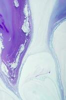 Abstract created using the technique of liquid acrylic. Macro photography of the smallest details of a panting. The panting shows how overflows of shades and colors of paint resemble space motifs. photo