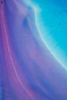 Abstract created using the technique of liquid acrylic. Macro photography of the smallest details of a panting. The panting shows how overflows of shades and colors of paint resemble space motifs. photo