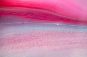 Abstract created using the technique of liquid acrylic. Macro photography of the smallest details of a panting. The panting shows how overflows of shades and colors of paint resemble space motifs. photo