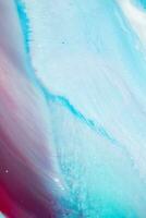 Abstract created using the technique of liquid acrylic. Macro photography of the smallest details of a panting. The panting shows how overflows of shades and colors of paint resemble space motifs. photo