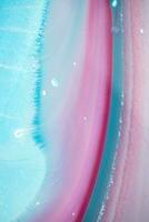 Abstract created using the technique of liquid acrylic. Macro photography of the smallest details of a panting. The panting shows how overflows of shades and colors of paint resemble space motifs. photo