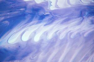 Abstract created using the technique of liquid acrylic. Macro photography of the smallest details of a panting. The panting shows how overflows of shades and colors of paint resemble space motifs. photo