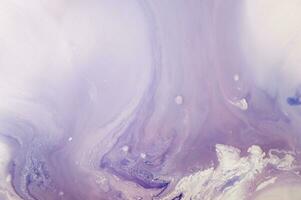 Abstract created using the technique of liquid acrylic. Macro photography of the smallest details of a panting. The panting shows how overflows of shades and colors of paint resemble space motifs. photo