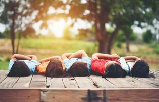 Group of kids friends arm around sitting together photo