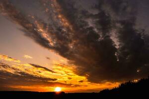 Blue violet red sunset sky background with evening curly rolling clouds may use for sky replacement photo