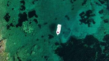 Aerial ascending top down view of boat in bay in Sardinia video