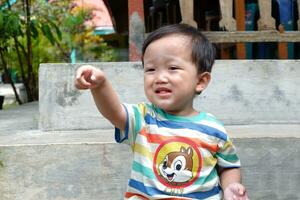 little boy pointing hand while crying photo