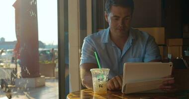 homem usando tábua computador dentro cafeteria video