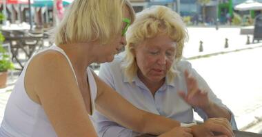 Senior women in street cafe using smart watch video