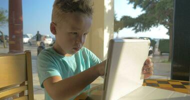 Child playing with pad in street cafe video