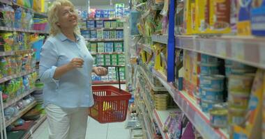 anziano donna acquisto animale domestico cibo nel il memorizzare video