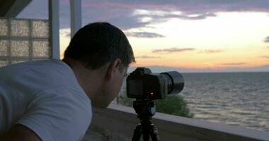 Man shooting timelapse of sunset over the sea video