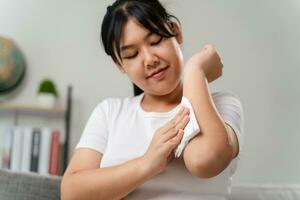 mujer toallitas limpieza su brazo con un pañuelo de papel papel toalla. cuidado de la salud y médico concepto. foto
