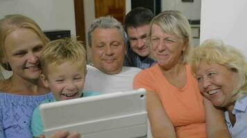 Family with child watching interesting video on pad