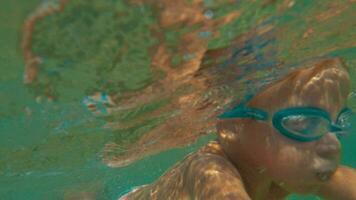 mutig wenig Junge Schwimmen unter Wasser video