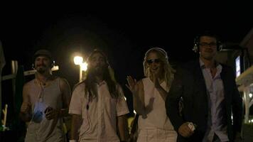 groupe de copains en marchant avec la musique rythmes à nuit video