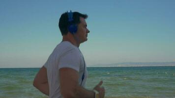 homme le jogging avec la musique à le bord de mer video