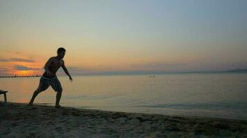 Man showing acrobatics at seaside during sunset video