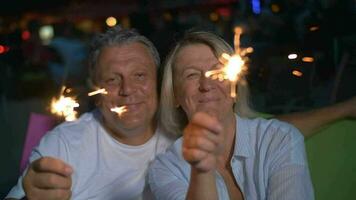 Happy senior man and woman with sparklers video