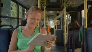 Lycklig Söt blond med läsplatta pc ridning i de buss video