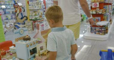 Child is attracted with toy cooker in supermarket video