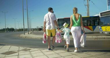 Family with shopping bags crossing the road video