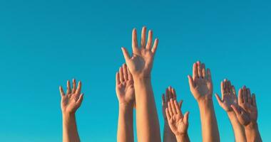 Raised hands against blue sky video