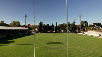 Aerial drone through goal posts on rugby pitch, rugby field photo