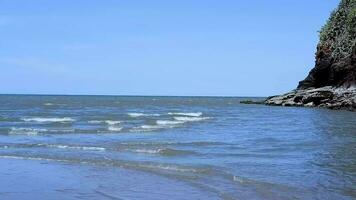 beautiful beach Ocean waves blowing onto the beach with mountains nearby and beautiful clouds video