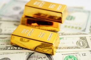 Gold bars on US dollar banknote money, finance trading investment business currency concept. photo