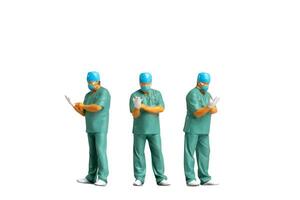 Miniature people Full length portrait of young doctor in scrubs Isolated on white background with clipping path photo