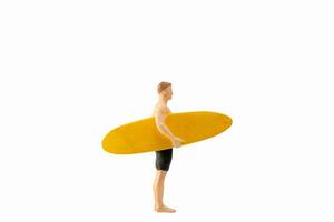 Miniature people man holding a yellow surfboard, isolated on white background with clipping path photo