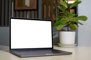 Blank screen of Laptop computer in workspace with plant pot photo