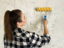 Woman with yellow Paint Roller. wall primer photo