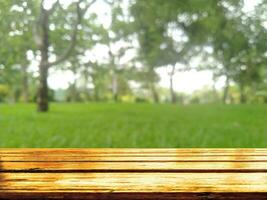 wooden table with blurred green grass in the background photo